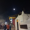 Full moon above small temple beside Boudha Stupa
